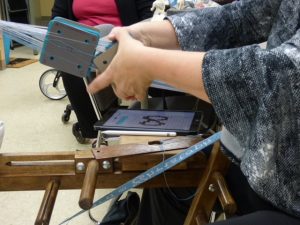 Hands working on tablet weaving.